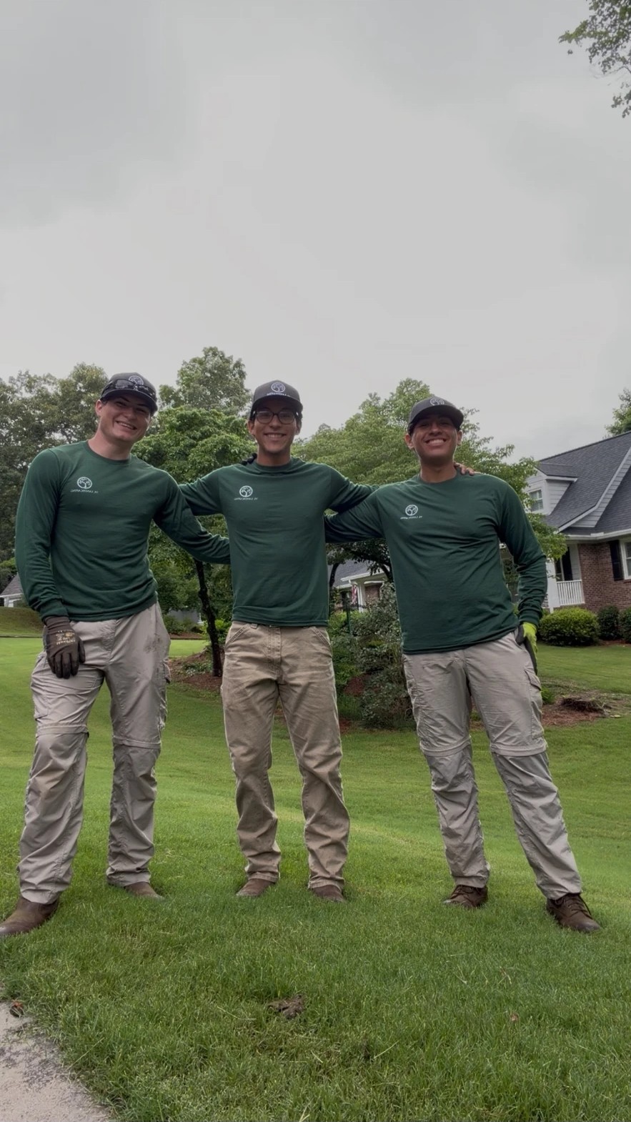 The VL Landscaping crew in matching green shirts standing on a freshly mowed lawn